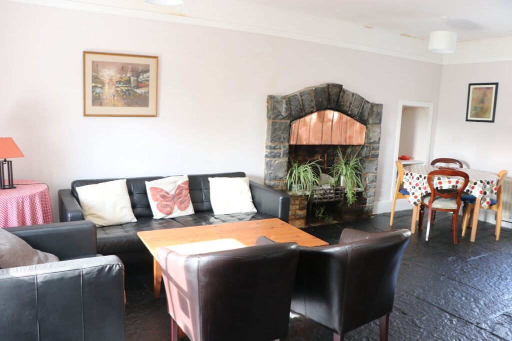 Sitting room with fireplace and sofas in Newtown House